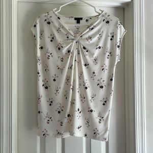 Light pink flowers on cream sleeveless blouse